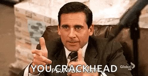 a man in a suit and tie is sitting in a chair giving a thumbs up .