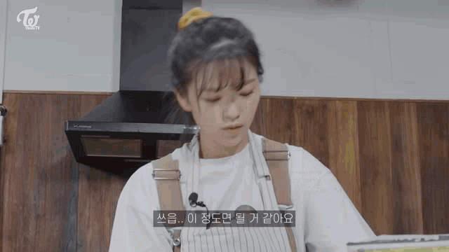 a woman in an apron is cooking in a kitchen with a twice logo in the corner .
