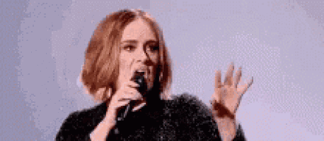 a woman is singing into a microphone on stage .
