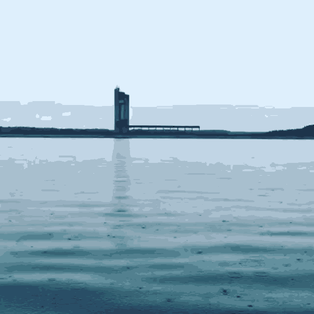 a very large body of water with a bridge in the distance