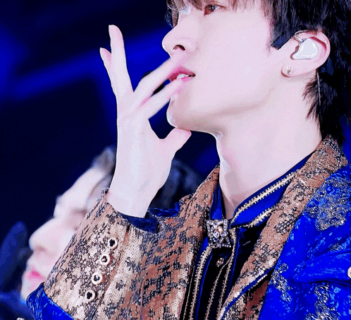 a close up of a person 's face with a blue and gold jacket on