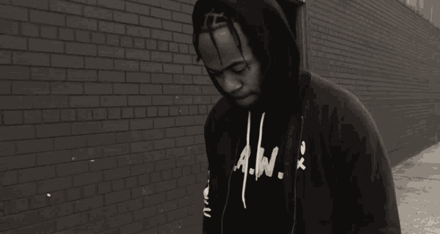 a black and white photo of a man wearing a hoodie with a.w. written on it