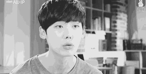 a black and white photo of a young man in a gray shirt .