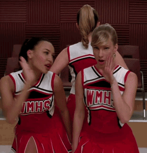 two cheerleaders wearing red and white uniforms that say mhs