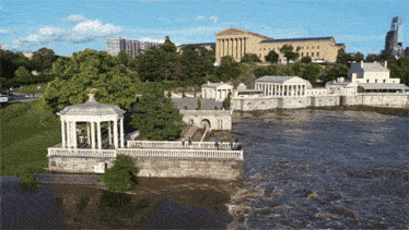 an aerial view of a river with a gazebo in the foreground and a building in the background