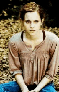 a woman in a brown shirt and blue jeans sits on the ground