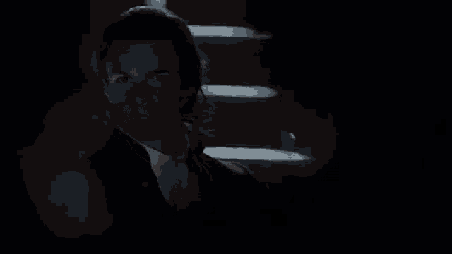 a man and a woman are standing in a dark room .