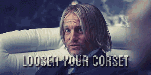a man is sitting on a couch with the words loosen your corset written below him