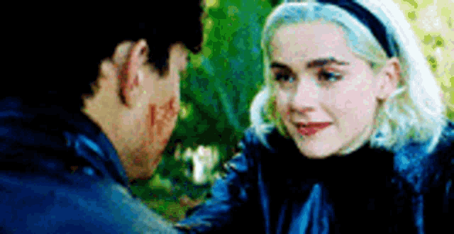 a man and a woman are looking at each other . the woman is crying .