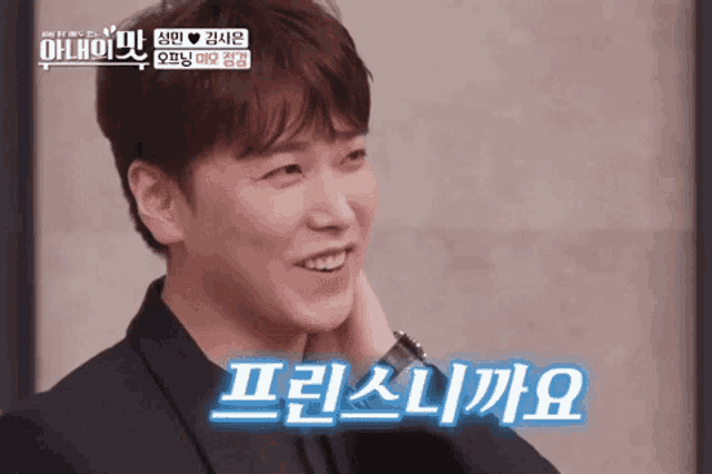 a man in a suit is smiling with korean writing on the bottom
