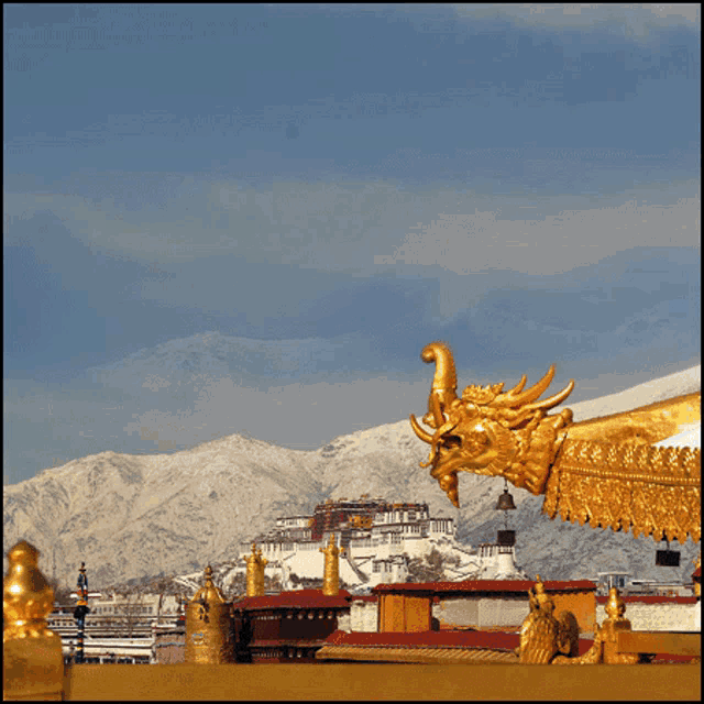 a picture of a temple with mountains in the background and a dragon statue in the foreground