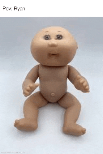 a baby doll is sitting on a white surface .