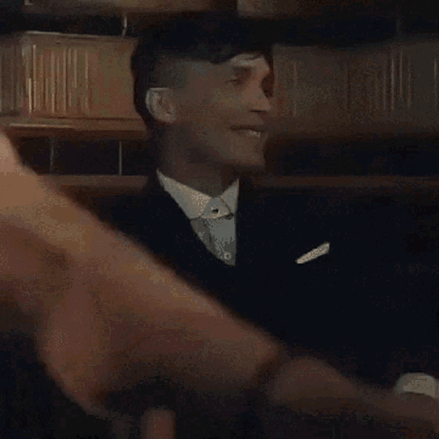 a man in a tuxedo and bow tie smiles for the camera