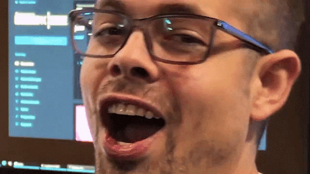a man with glasses and a beard is making a funny face