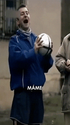 a man in a blue jacket is holding a soccer ball with the word mame written below him