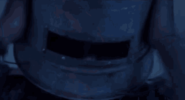 a close up of a person 's hand holding a bottle of water in a dark room .