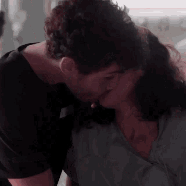 a man is kissing a woman on the forehead .