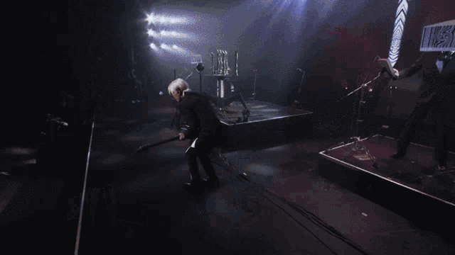 a man playing a guitar on a stage with a sign that says ' i 'm a ' on it