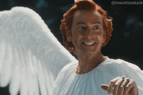 a man with red hair and white wings is wearing a white shirt and smiling