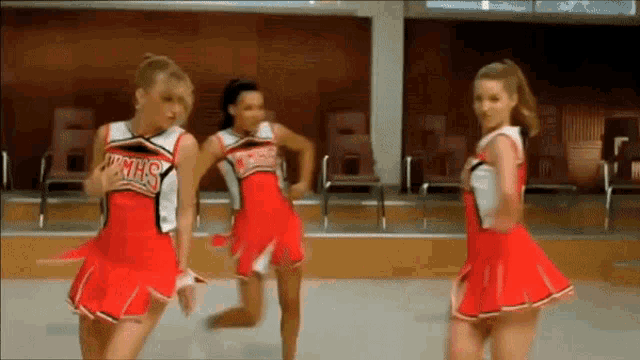 three cheerleaders wearing red uniforms with the word hmhs on the front