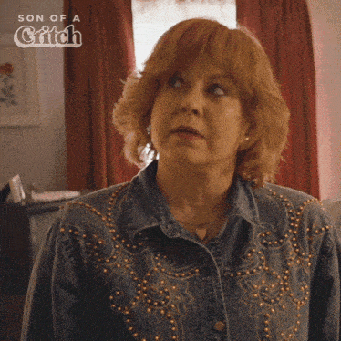a woman is wearing a denim jacket with gold studs and the words son of a grifch on the bottom right
