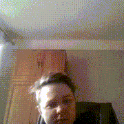 a blurry picture of a person 's face in a room with wooden cabinets