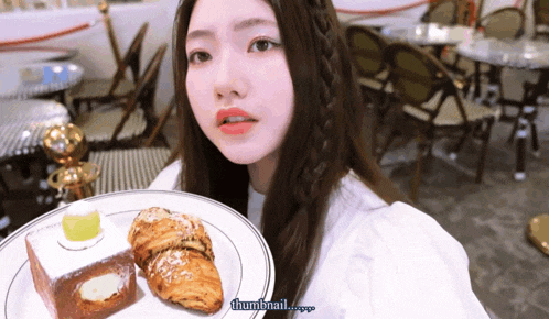 a girl is holding a plate of food with the words thumbnail written below her