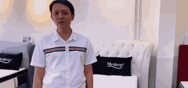 a man stands in front of a bed with a pillow that says mysleep