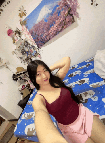 a woman laying on a bed with a painting on the wall above her