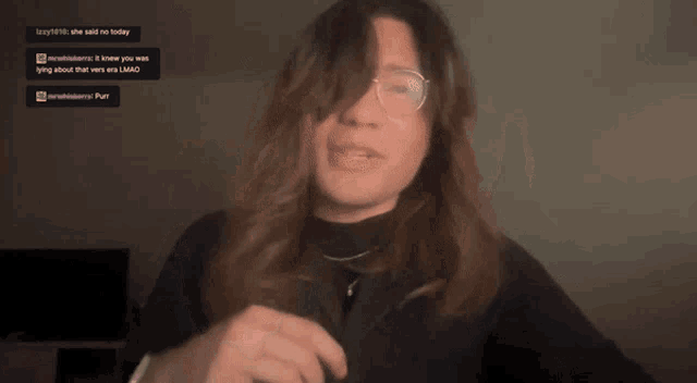 a woman wearing glasses and a black turtleneck is talking to someone on a twitch channel