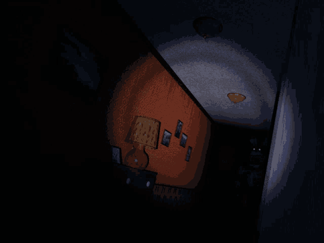 a dimly lit room with a lamp and a few pictures on the wall