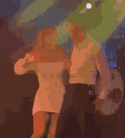 a man and a woman are hugging each other in a dark room