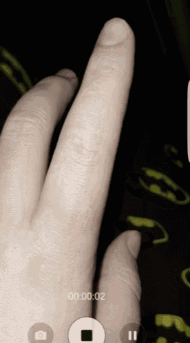 a close up of a person 's hand with a pause button in the corner