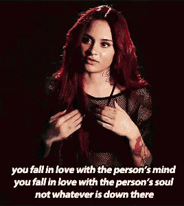 a woman with red hair has a tattoo on her arm ..