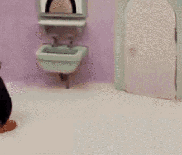 a penguin in a bathroom with a sink and mirror