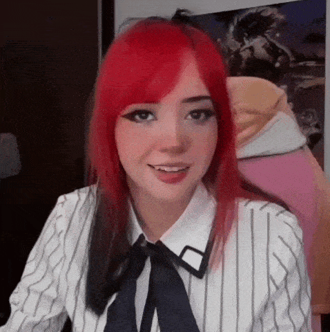 a girl with red hair and black eyes is wearing a striped shirt and a bow tie .