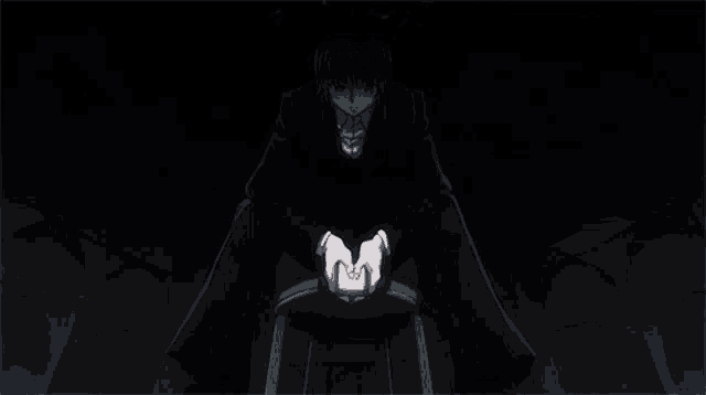 a man in a black suit is sitting on a stool