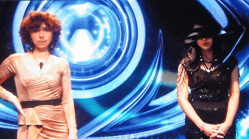 two women standing in front of a blue circle