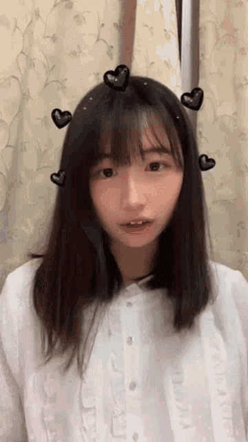 a young girl with hearts on her hair and a white shirt