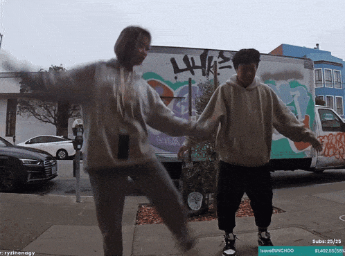 a man and a woman are dancing in front of a truck with graffiti on it