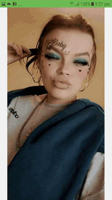 a woman with a tattoo on her face that says " baby "
