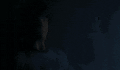 a silhouette of a person standing in front of a window at night