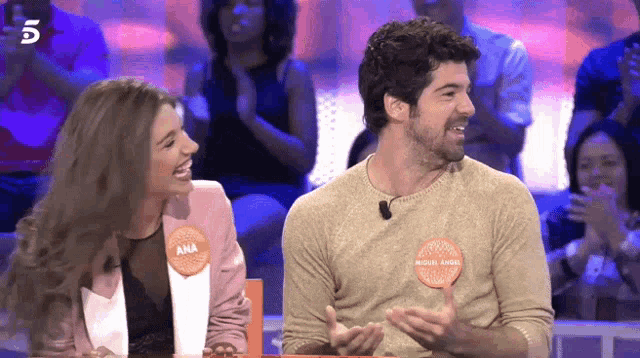 a man and a woman are sitting next to each other and the woman has a name tag that says ana on it