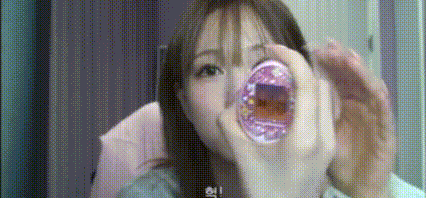 a woman is holding a donut in her mouth and making a face .