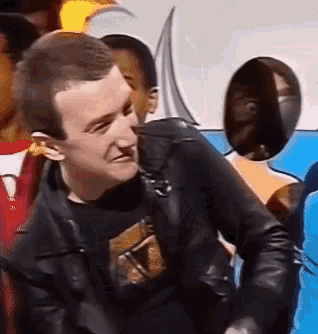 a man wearing a black jacket and a black shirt that says ' x '