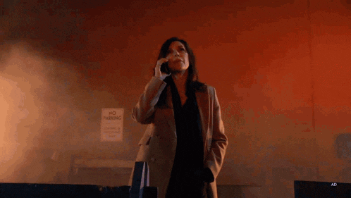 a woman talking on a cell phone in front of a red background