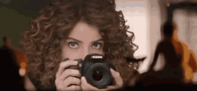 a woman taking a picture with a canon camera