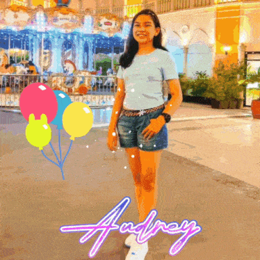 a girl is standing in front of a merry go round with the name andrey written on the bottom