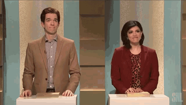a man and a woman are standing next to each other on a snl stage