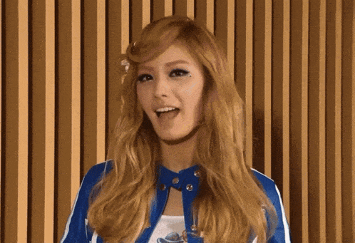 a woman with blonde hair is wearing a blue jacket and a white shirt .